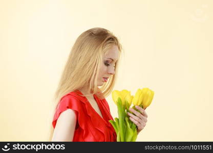 Shot of young woman holding romantic yellow tulip bouquet. Women day gift. Studio shot on light background.. Young woman holding tulip bouquet