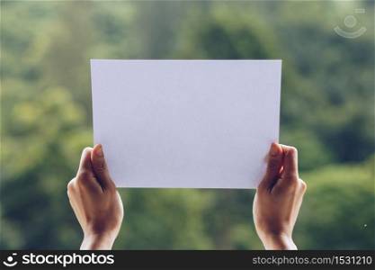 Show business paper in hand on nature background
