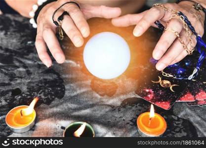 Show fortune tellers of hands holding tarot cards and tarot reader with candle light and magic Crystal ball, Performing readings magical performances, Things mystical astrologists forecasting concept