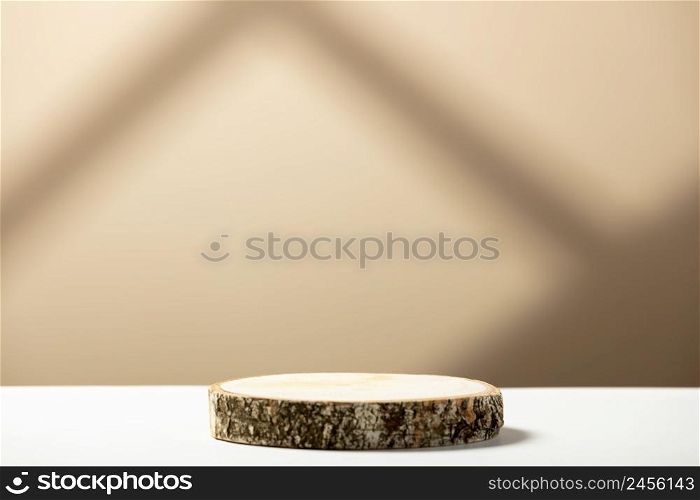 Showcase for cosmetic products. Product advertisement. Layout style design. Wood slice podium on a beige background with shadows. Natural cosmetics and beauty concept