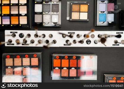 Showcase with powder and shadows in cosmetics store, nobody. Luxury beauty shop, shelf with products in fashion store. Showcase with powder and shadows, cosmetics store