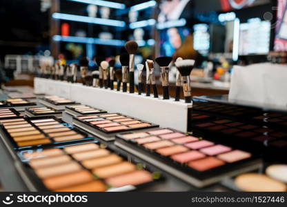 Showcase with powder and shadows in cosmetics store, nobody. Luxury beauty shop, shelf with products in fashion market. Showcase with powder and shadows, cosmetics store