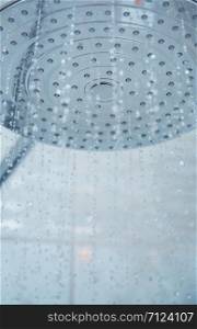 Shower head with flowing water. Close-up vertical photo