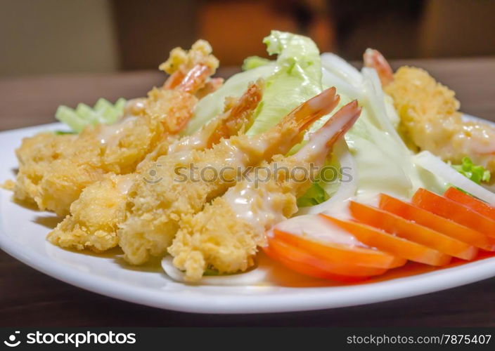 shrimp and salad. deep fried shrimp and fresh vegetable salad on white dish
