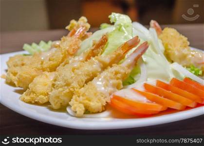 shrimp and salad. deep fried shrimp and fresh vegetable salad on white dish