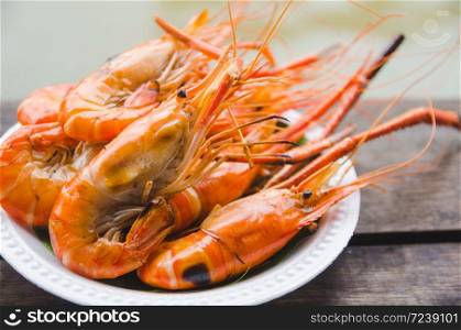 shrimp grilled on white plate on wooden table
