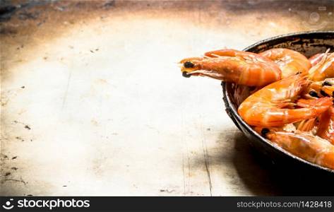Shrimp in an old pan. On an old rustic background .. Shrimp in an old pan.