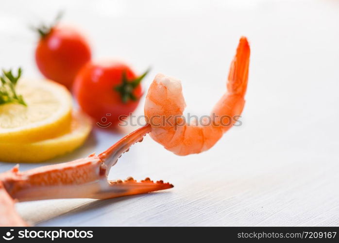 Shrimp on crab claws with tomato lemon decorate on dining table background