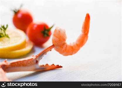 Shrimp on crab claws with tomato lemon decorate on dining table background