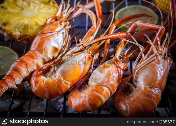 shrimp,prawn grilled on barbecue stove with lemon and pineapples
