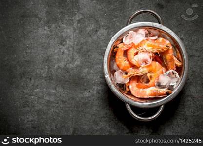 Shrimp with ice in a metal bowl . On a stone background.. Shrimp with ice in a metal bowl .