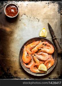 Shrimp with lemon and sauce. On an old rustic background .. Shrimp with lemon and sauce.