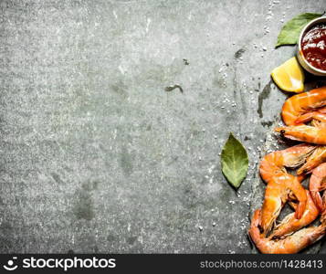 Shrimp with sauce, lemon and salt . On a stone background.. Shrimp with sauce, lemon and salt .
