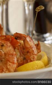 Shrimps grilled with lemon on the plate. Fresh seafood dish. Shallow depth of field. 