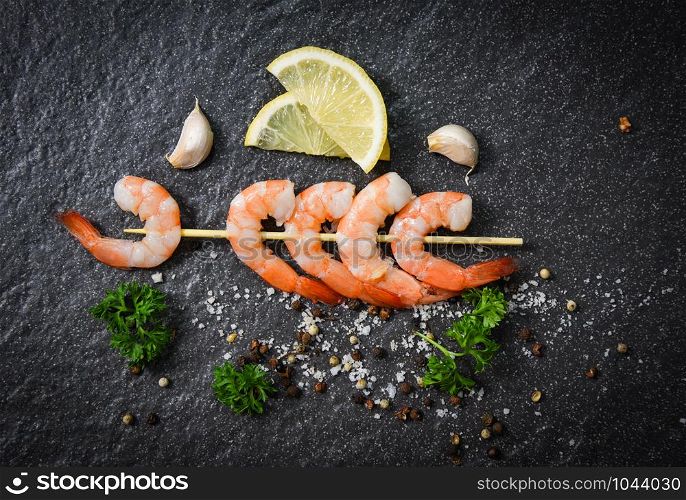 Shrimps prawns in skewer sticks seafood cooked with herbs and spices on dark background