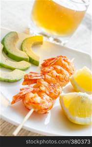 Shrimps skewers with avocado and lemon slices