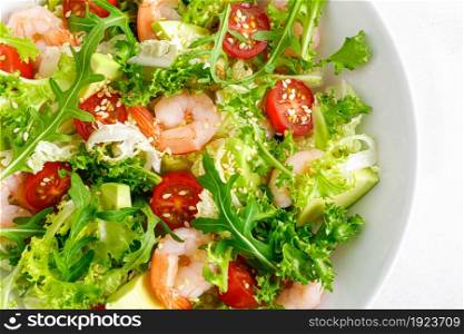 Shrimps, tomato and avocado summer vegetable salad with fresh lettuce, rocket and sesame. Healthy eating. Keto, ketogenic diet. Top view.