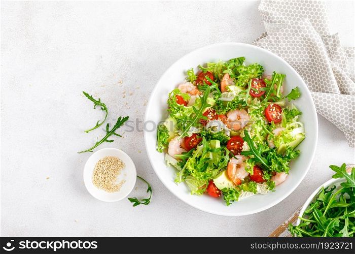 Shrimps, tomato and avocado summer vegetable salad with fresh lettuce, rocket and sesame. Healthy eating. Keto, ketogenic diet. Top view.