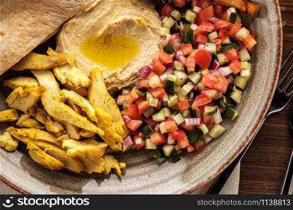 Shwarma in a plate with hummus and salad