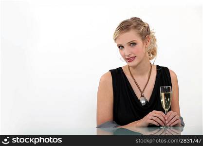 shy blonde with flute of champagne against white background