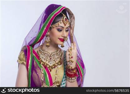 Shy Indian bride against gray background