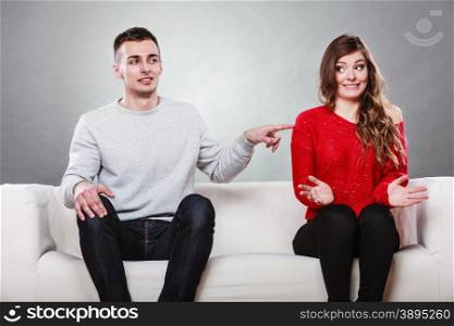 Shy woman and man sitting on sofa couch next each other. First date. Attractive girl and handsome guy meeting dating and trying to talk. Male touching picking up female.. Shy woman and man sitting on sofa. First date.