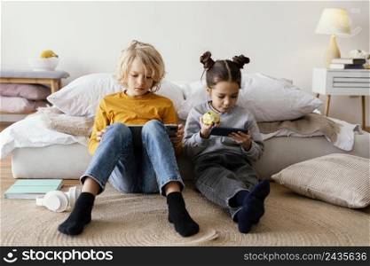 siblings bed playing mobile tablet 3