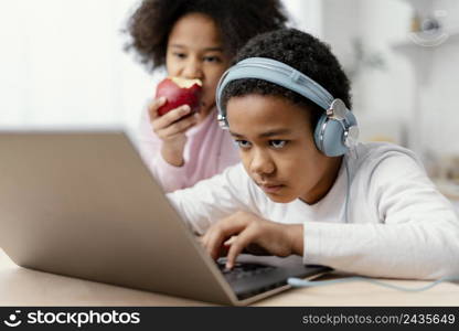 siblings listening music using laptop