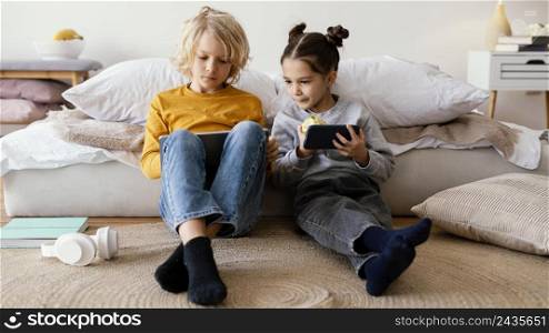 siblings playing with mobile tablet