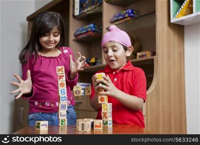 Siblings playing with wooden toy blocks