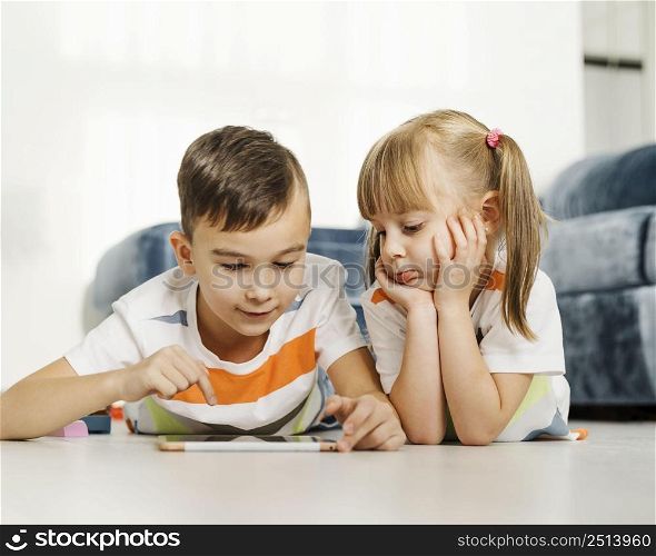siblings using digital tablet