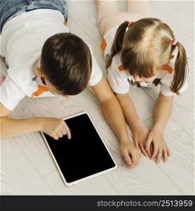 siblings using digital tablet high view