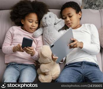 siblings using tablet mobile home
