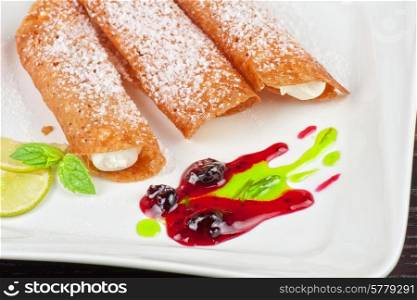 Sicilian cannoli at plate decorated with lime and jam. Sicilian cannoli