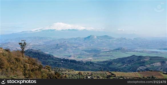 Sicilian rural landscape in winter with snow peak of Etna volcano in Italy