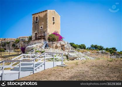 Sicily, Italy. Old house with purple flowers in Syracuse.. Traditional old Sicilian house during a sunny day with a wonderful blue sky background.