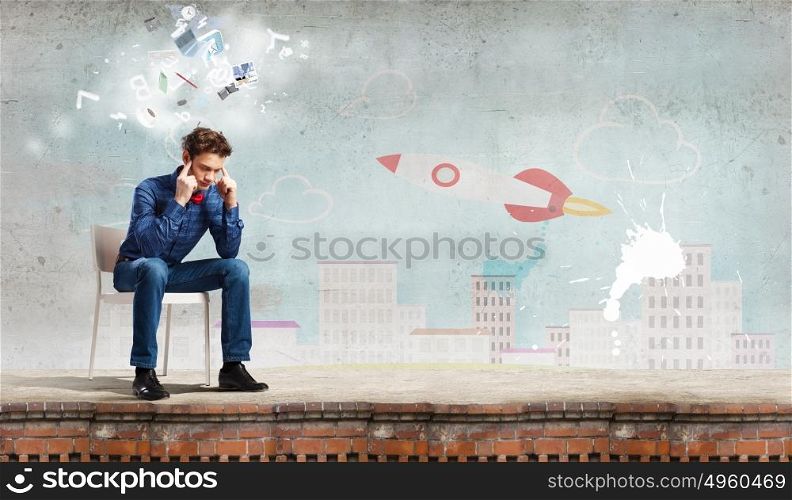 Sick and tired!. Troubled young man sitting in chair outdoors