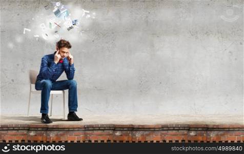 Sick and tired!. Troubled young man sitting in chair outdoors