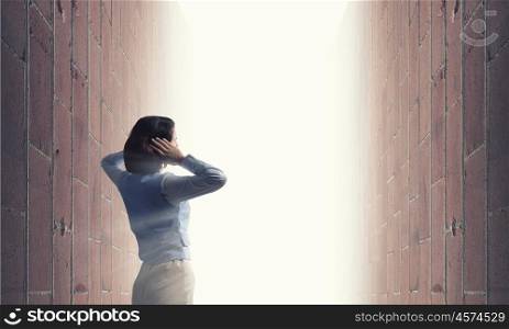 Sick and tired. Young frustrated woman standing with back covering ears with arms