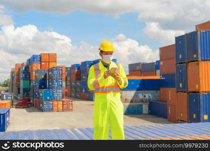 Sick Asian logistic worker engineer man working in cargo container,wearing a face mask in warehouse industry factory site. Export, import concept. Business people. Corona virus and health care concept