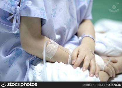 Sick child on a receiving a saline solution in hospital