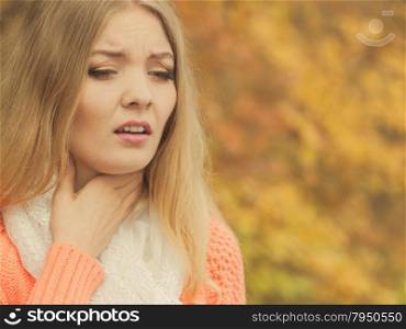 Sick ill woman in autumn park.. Sick woman in fall autumn park. Ill girl caught cold flu outdoor. Rhinitis or allergy. Health care.