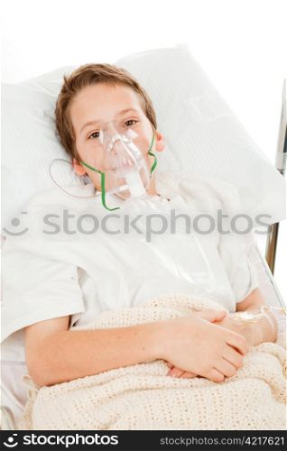 Sick little boy in the hospital breathing with an oxygen mask.