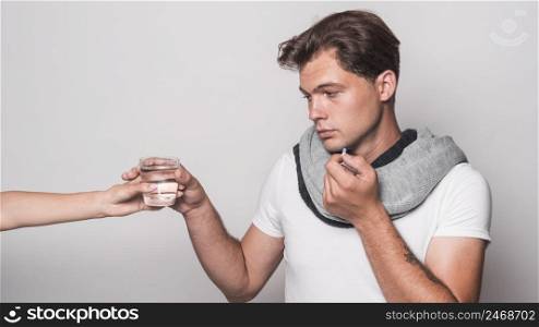 sick man holding capsule taking glass water from person s hand