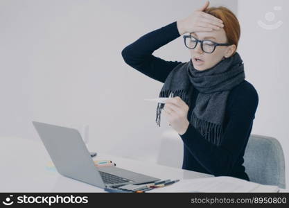 Sick manager at online conference. Young white woman got disease in office. Unwell girl is working in scarf holding thermometer and shocked with her temperature. Worker feels ill and has fever.. Sick manager at online conference. Unwell girl is shocked with her temperature and fever.