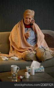 Sick retired woman talking with doctor phone at home. Remote medical consultation on smartphone. Sick retired woman talking smartphone at home
