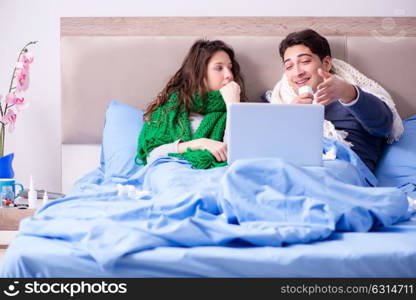 Sick wife and husband in bed with laptop