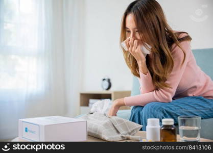 Sick woman. Beautiful female health problem blowing nose use pharmacy kit box delivery service from hospital, delivery pharmacy concept, Asian young girl cold sick she sneeze with tissue paper on sofa