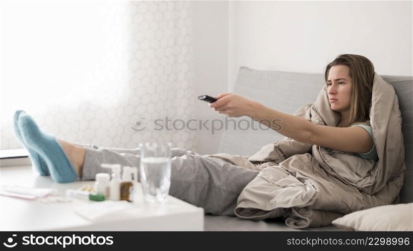 sick woman sitting bed watching tv