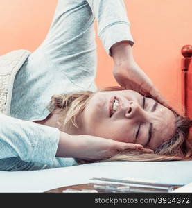 Sick woman suffering from headache pain.. Sick woman suffering from headache pain. Ill girl laying in bed caught cold. Thermometer and pills on table.